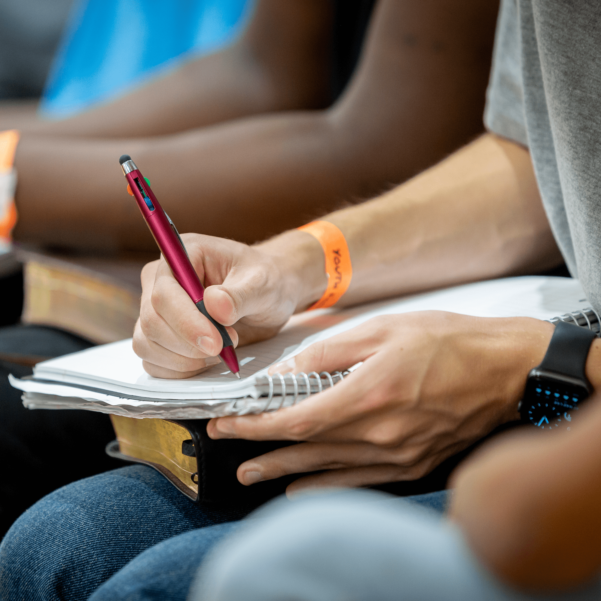 Close-up of a participant taking notes during a Bible study session at Anderson Hills Church