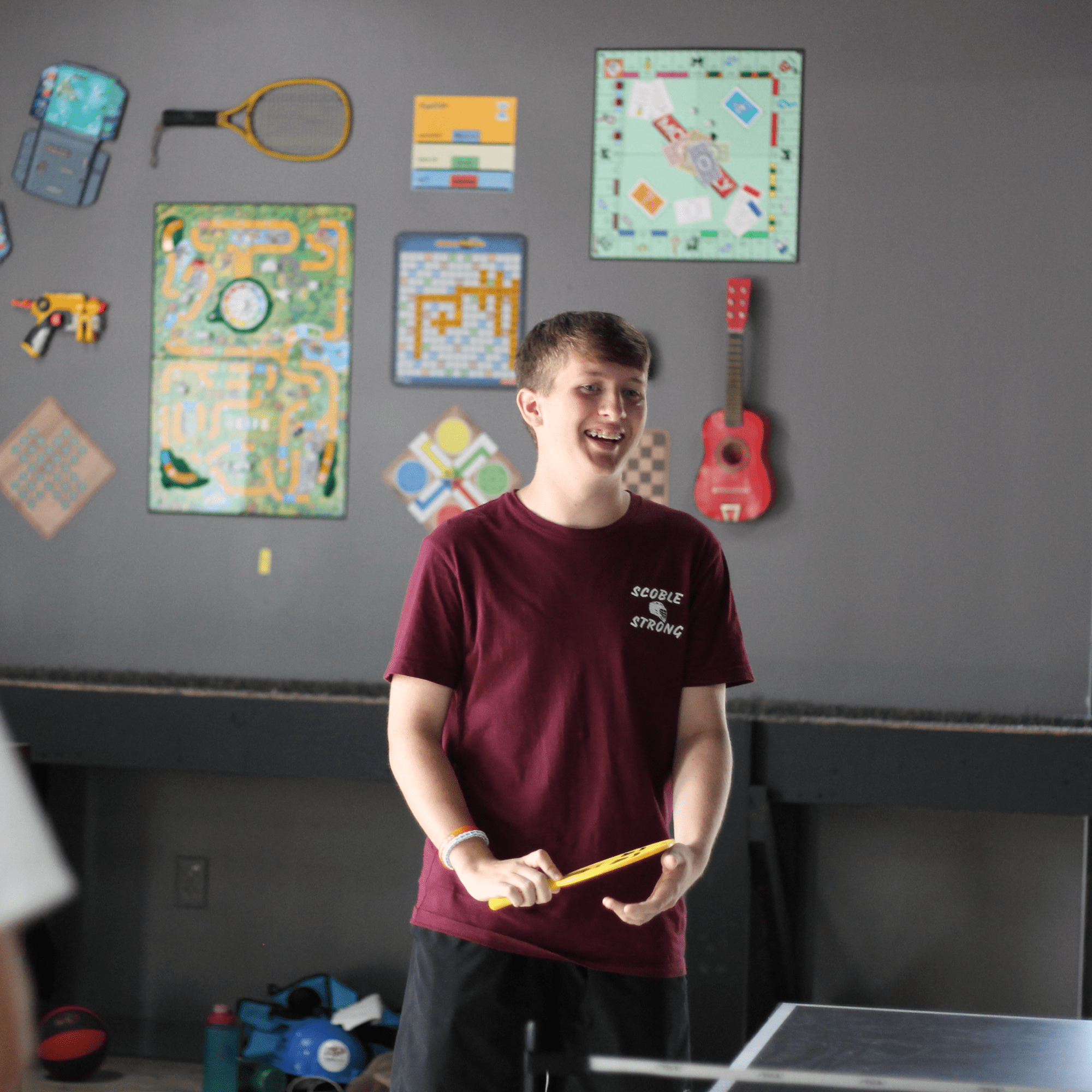 Teenage boy enjoying community fellowship in a game of table tennis in the youth activity room at Anderson Hills Church