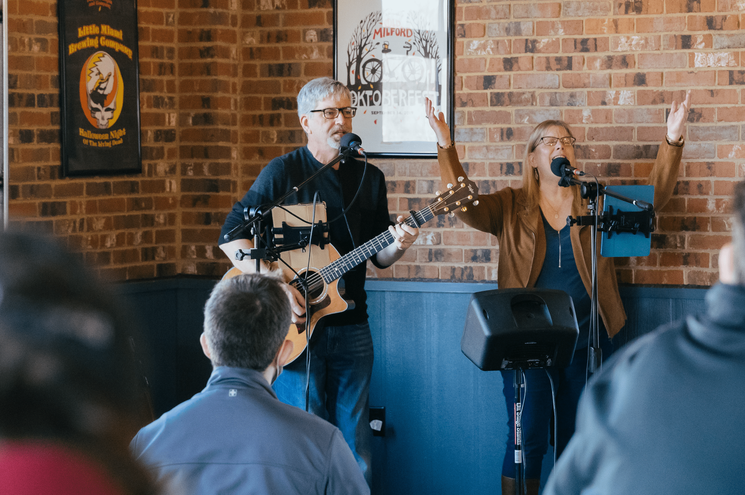 Musicians leading spirited worship with guitars and joyful singing at a Fresh Expressions event hosted by Anderson Hills Church in a communal space