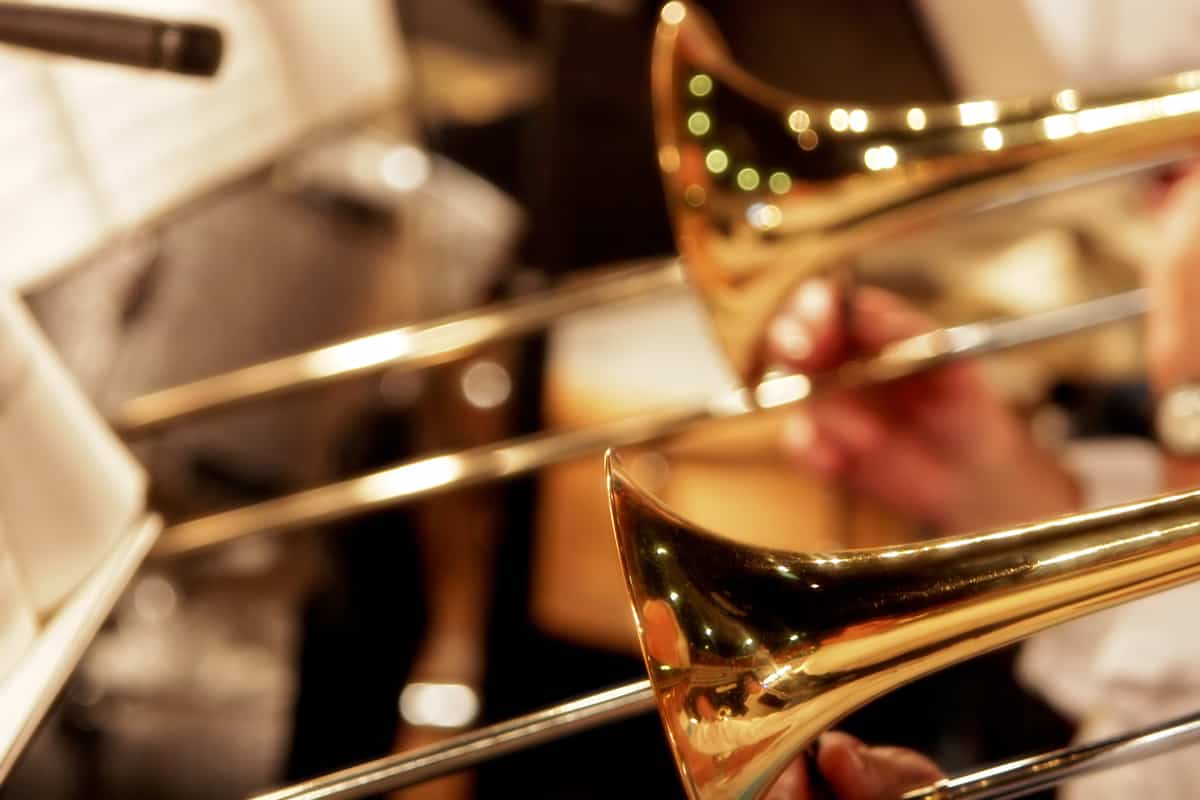 Close-up of trombones playing in a big band or orchestra - focus point on foreground trombone.